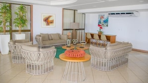Una sala moderna con muebles de mimbre, un conjunto de sofás, una mesita de centro y objetos decorativos.