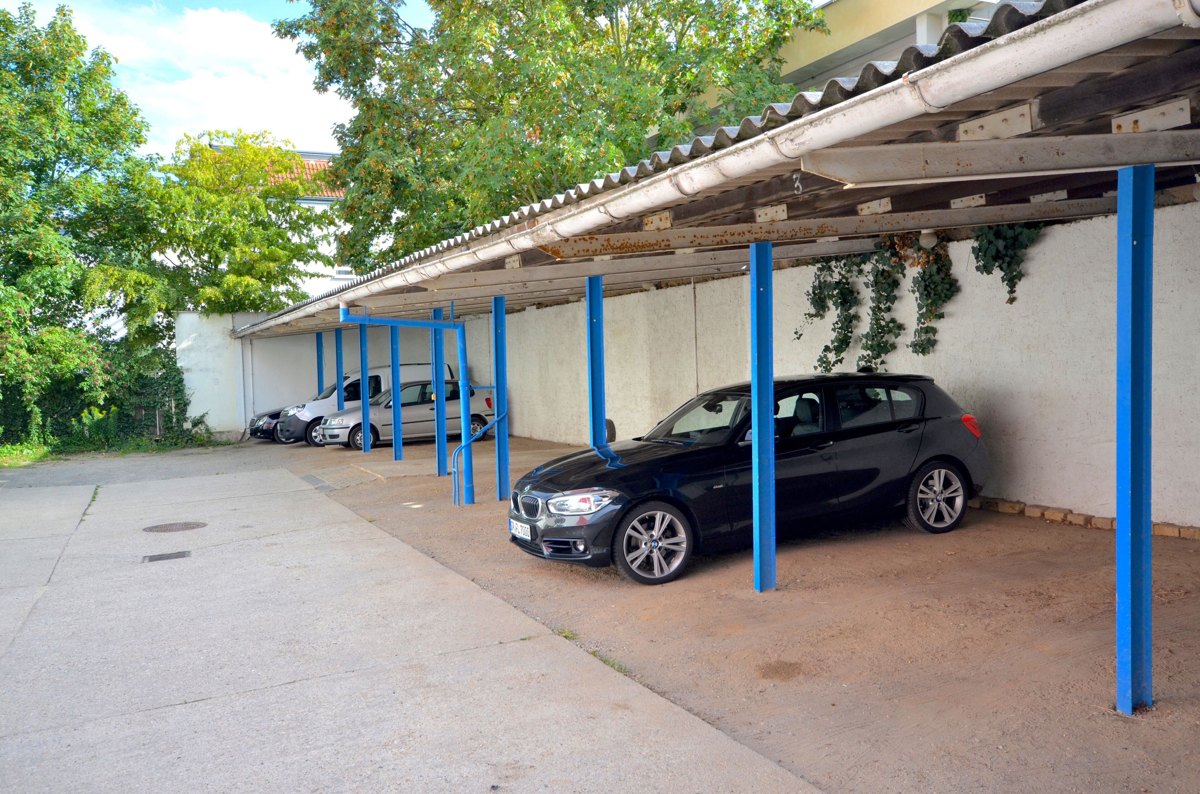 A parking garage with blue support columns and a covered area.