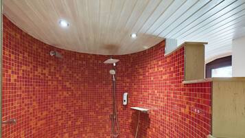 Una ducha con paredes de azulejos rojos y techo de madera.