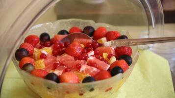 Ensalada de frutas en un bol de vidrio con una cuchara.