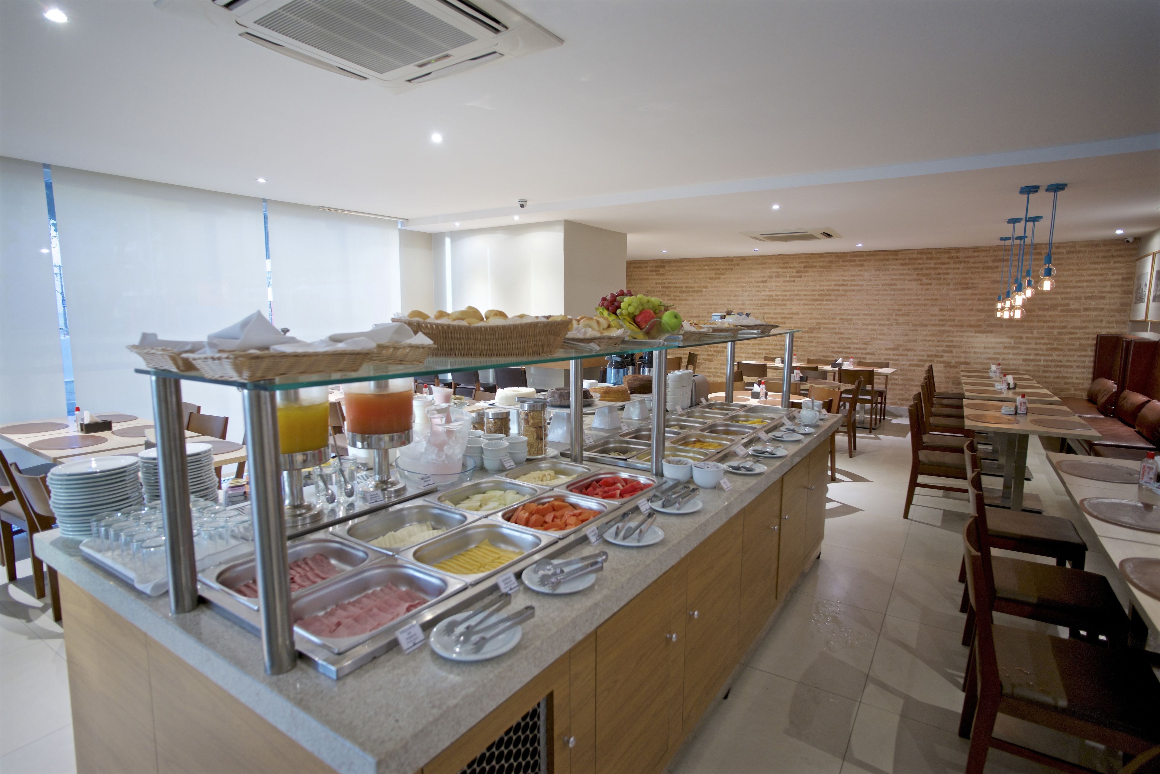 A buffet area with various food stations, including fruits, meats, and beverages.
