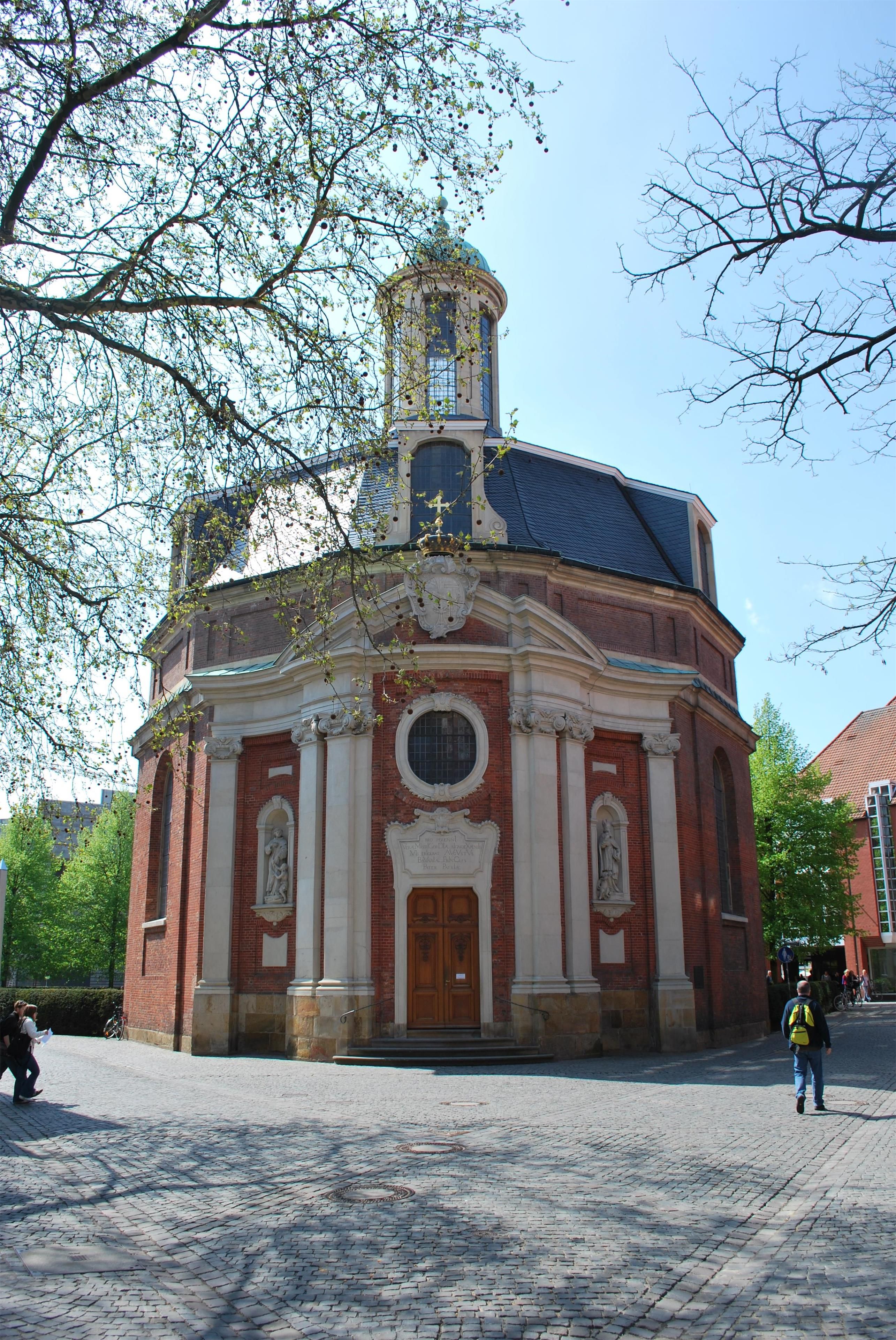 Ein historisches Gebäude mit einer zentralen Kuppel, Bogenfenstern und einem markanten Eingang.