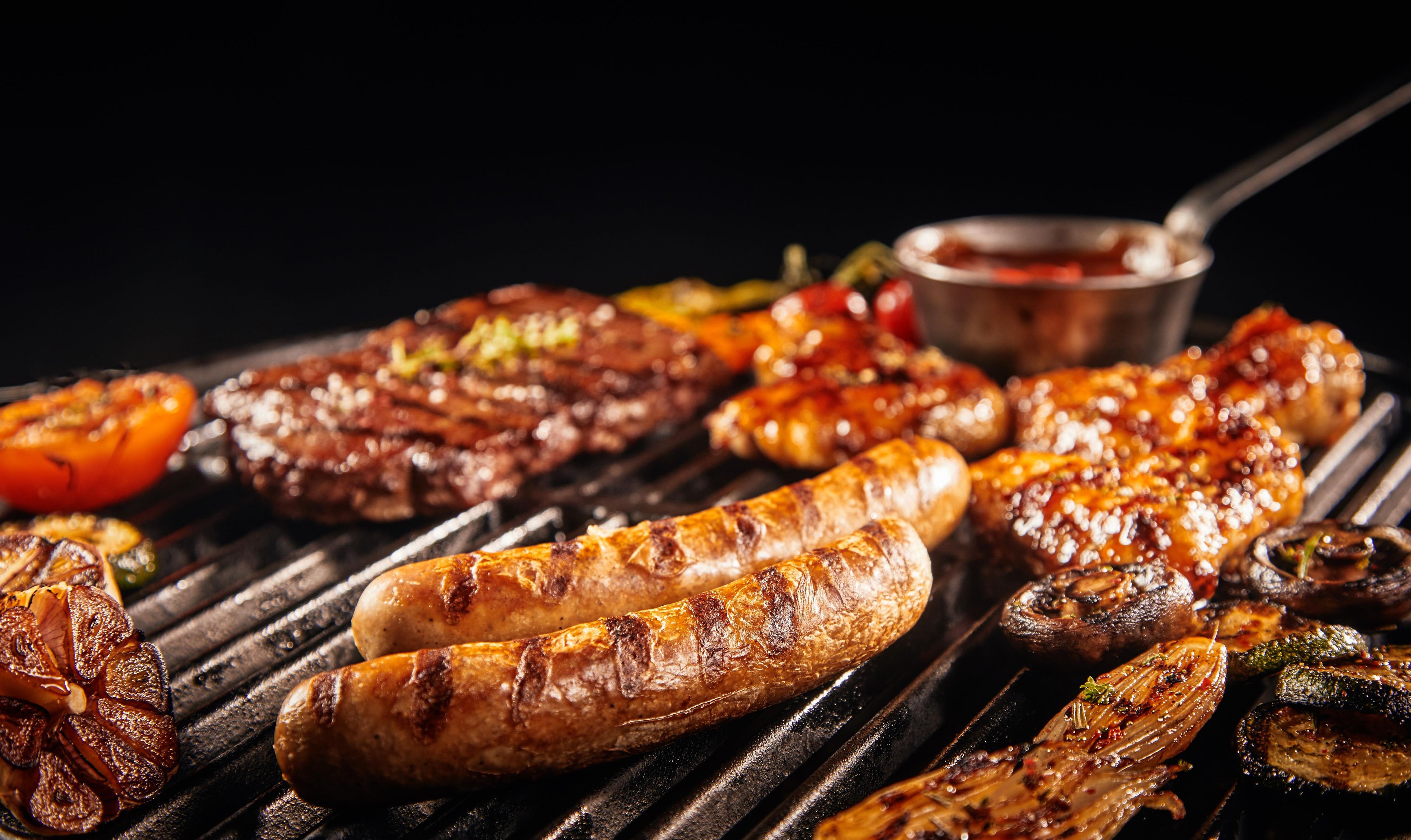 A variety of grilled meats and vegetables on a grill.