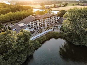 Un hotel moderno con patio, piscina y vistas al río.
