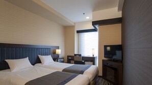 Habitación de hotel con dos camas, un escritorio, un televisor y una ventana con persianas.