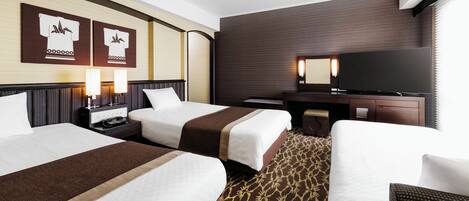 A hotel room with two beds, a TV, a desk, and a large window.