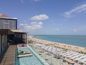 A pool area with a view of the beach and ocean.
