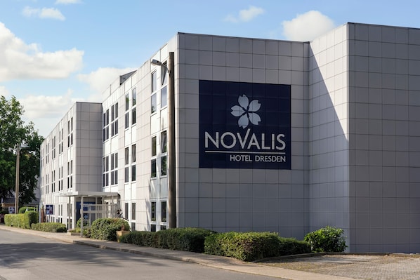 Un moderno edificio de hotel con un cartel llamativo del Hotel Novalis Dresden.