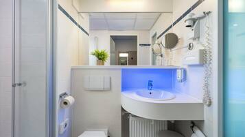 Een moderne badkamer met een wit wastafelmeubel, een spiegel, een handdoekhouder en een toilet.