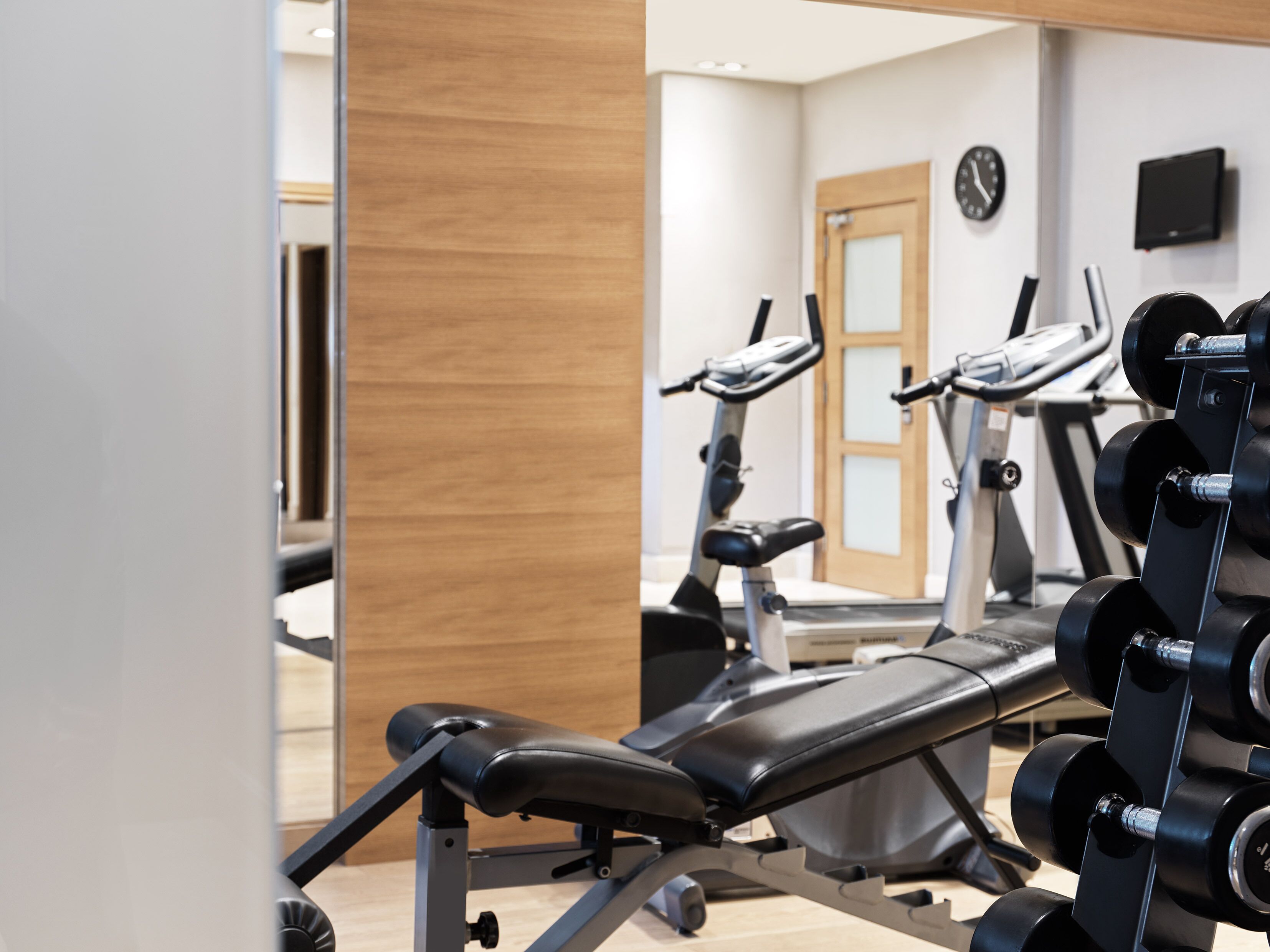 A gym with exercise equipment, including a bench and weight racks.