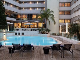 Um hotel com piscina, área de estar externa e restaurante.