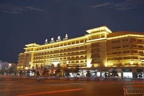 Un hotel de varios pisos con un letrero llamativo en la parte superior.