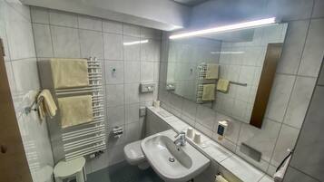 Ein modernes Badezimmer mit Waschbecken, Toilette und Handtuchhalter.
