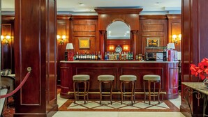 Eine Bar mit Holzwandverkleidung, Marmorboden und Barhocker.