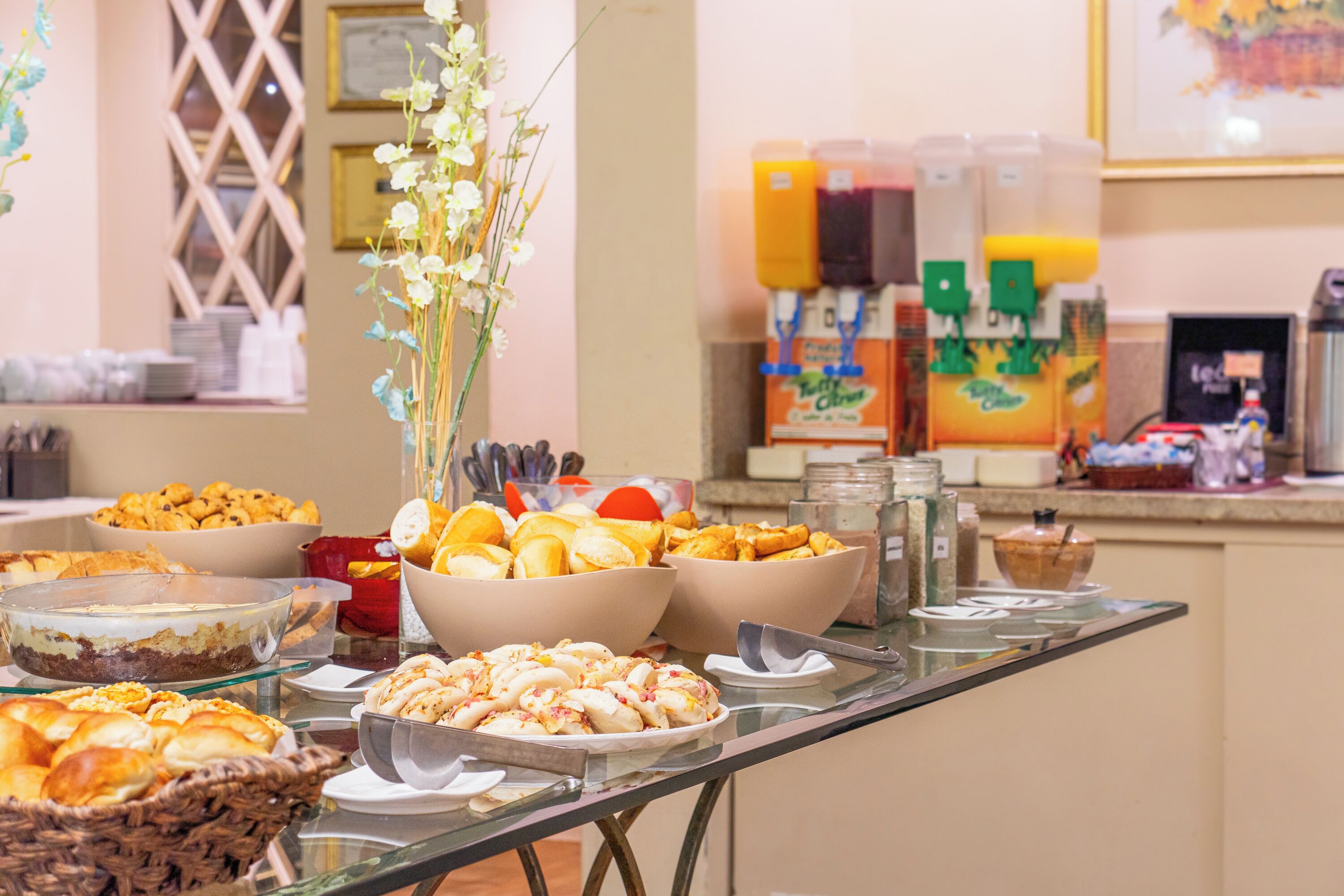 Un bufé con diversos alimentos y un dispensador de jugo.