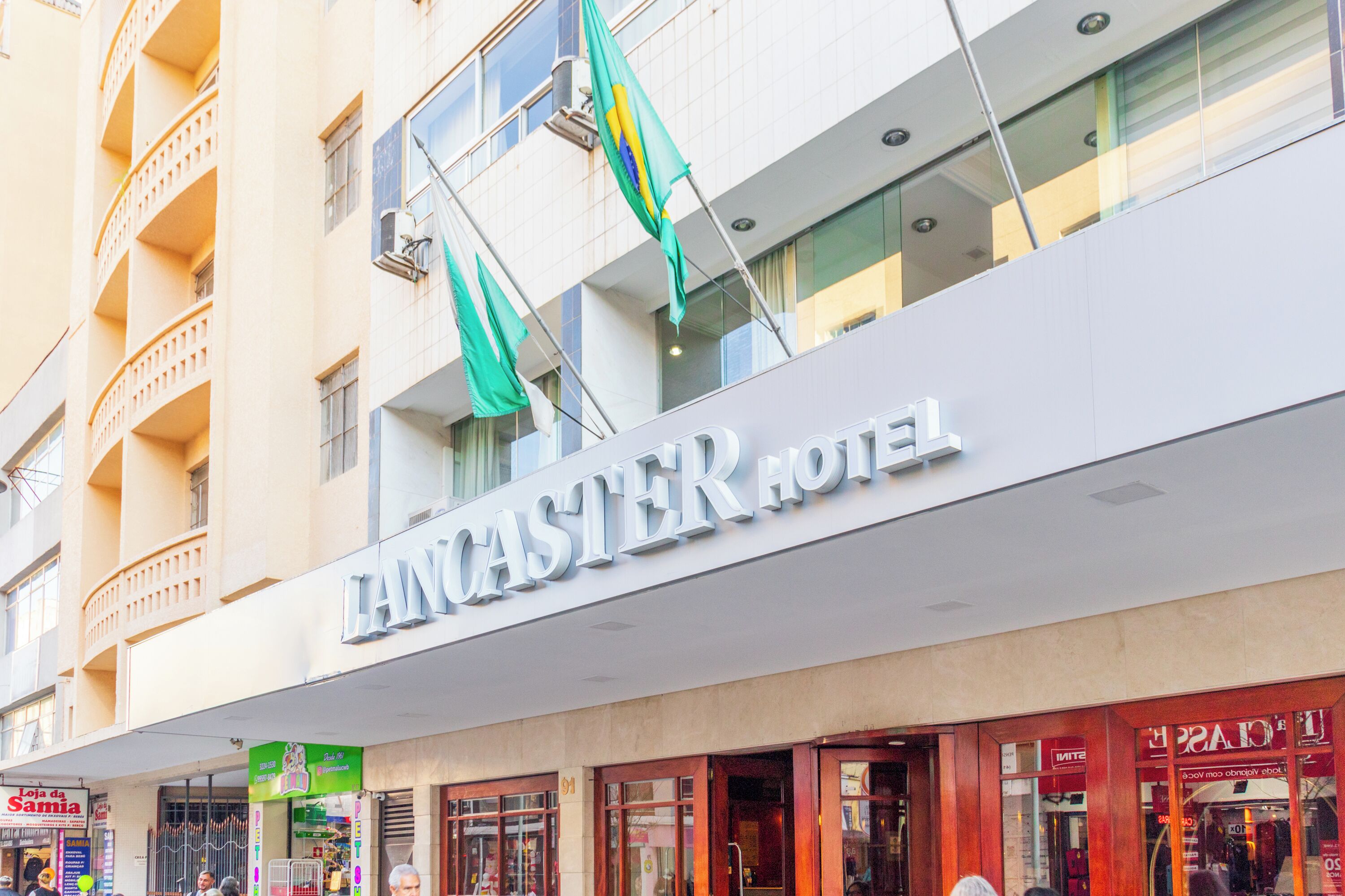 The Lancaster Hotel facade with a prominent sign, balconies, and storefronts.
