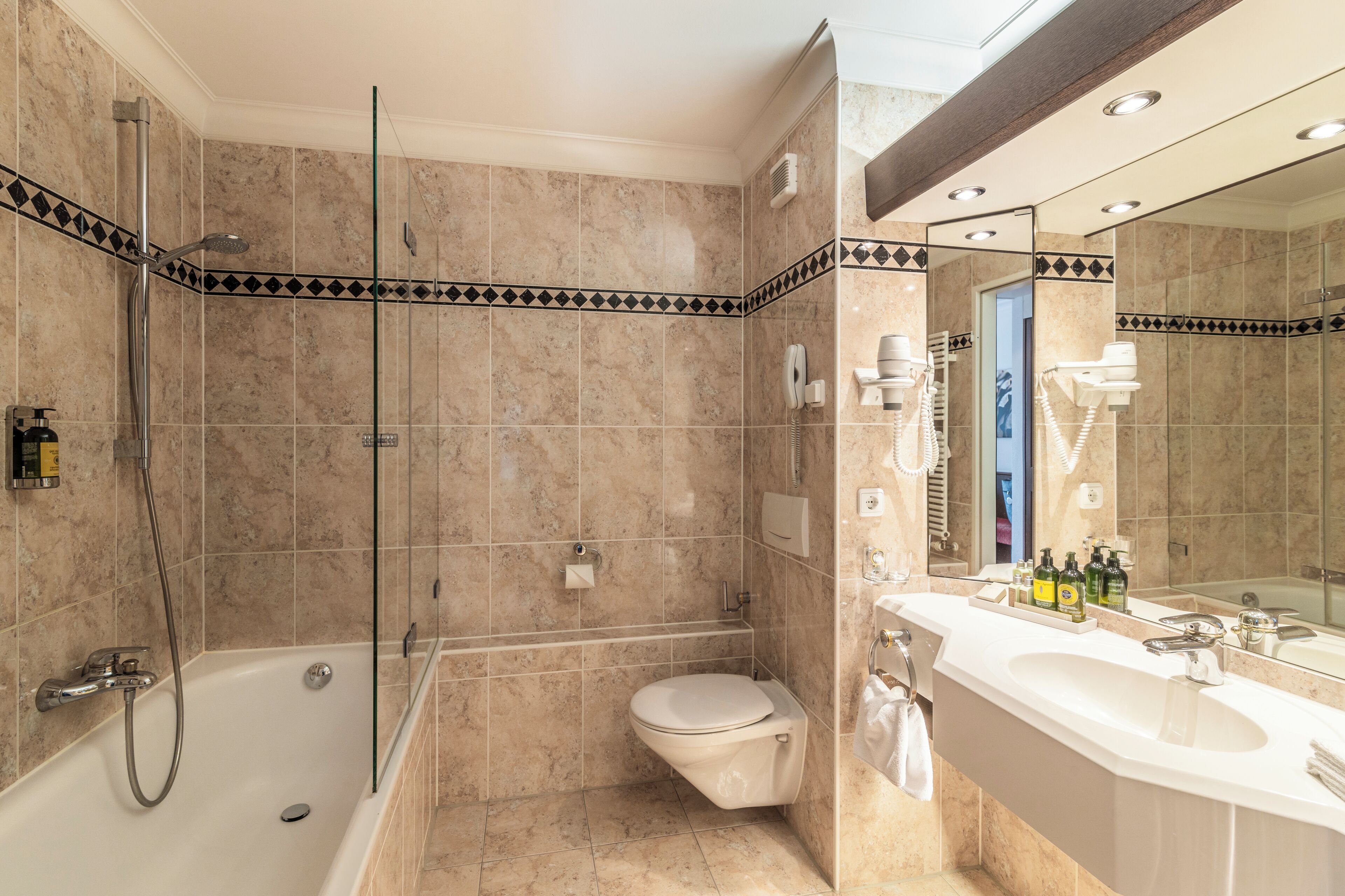 A modern bathroom with a bathtub, toilet, and shower area.