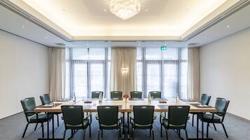 A conference room with a long table, chairs, and a chandelier.