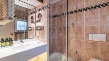 Ein modernes Badezimmer mit einem großen Spiegel, zwei Waschbecken, einer Dusche und einem WC.