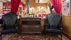 A room with two black upholstered chairs, a wooden cabinet, and red curtains. - Best Western Hotel Gamla Teatern (Östersund)