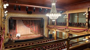 A theater with a grand chandelier, a stage with curtains, and rows of red seats. - Best Western Hotel Gamla Teatern (Östersund)