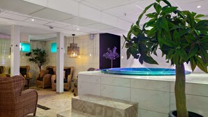 A spa area with a hot tub, wicker furniture, and a staircase leading to a seating area. - Best Western Hotel Gamla Teatern (Östersund)