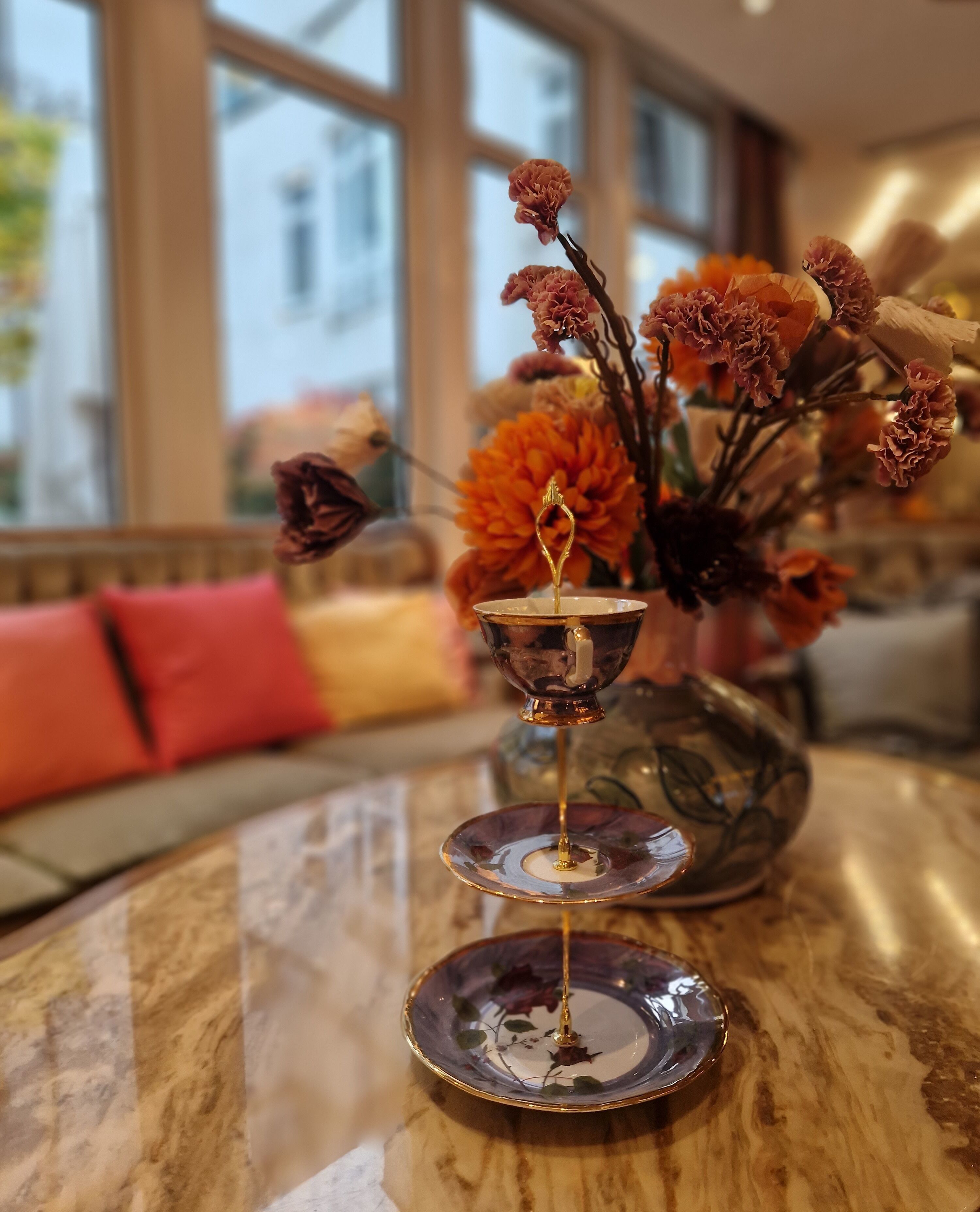 Una mesa con un jarrón decorativo que contiene flores y un candelabro.