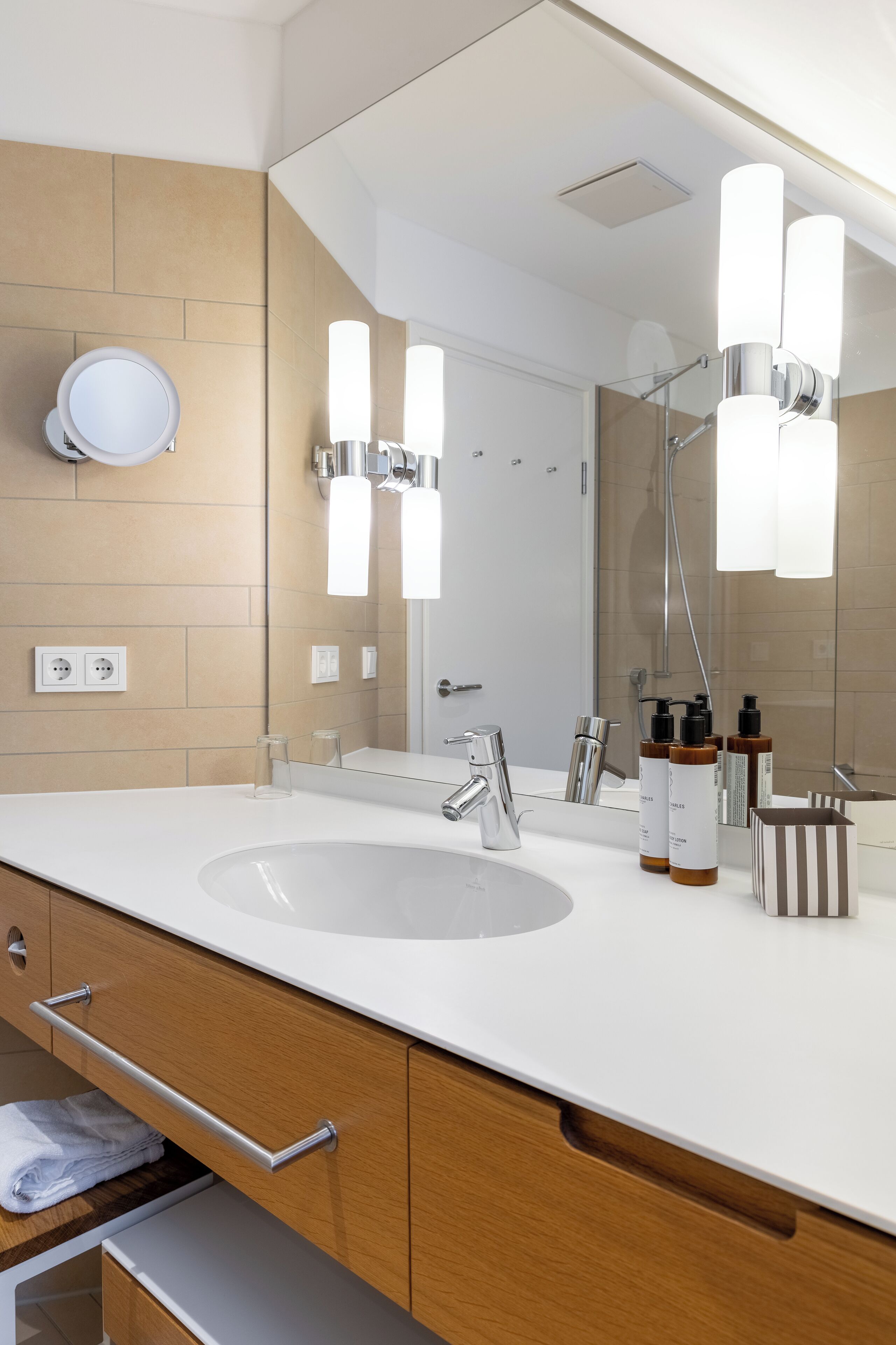 Ein modernes Badezimmer mit einem großen Waschbecken, einem Spiegel und zwei Wandleuchten.