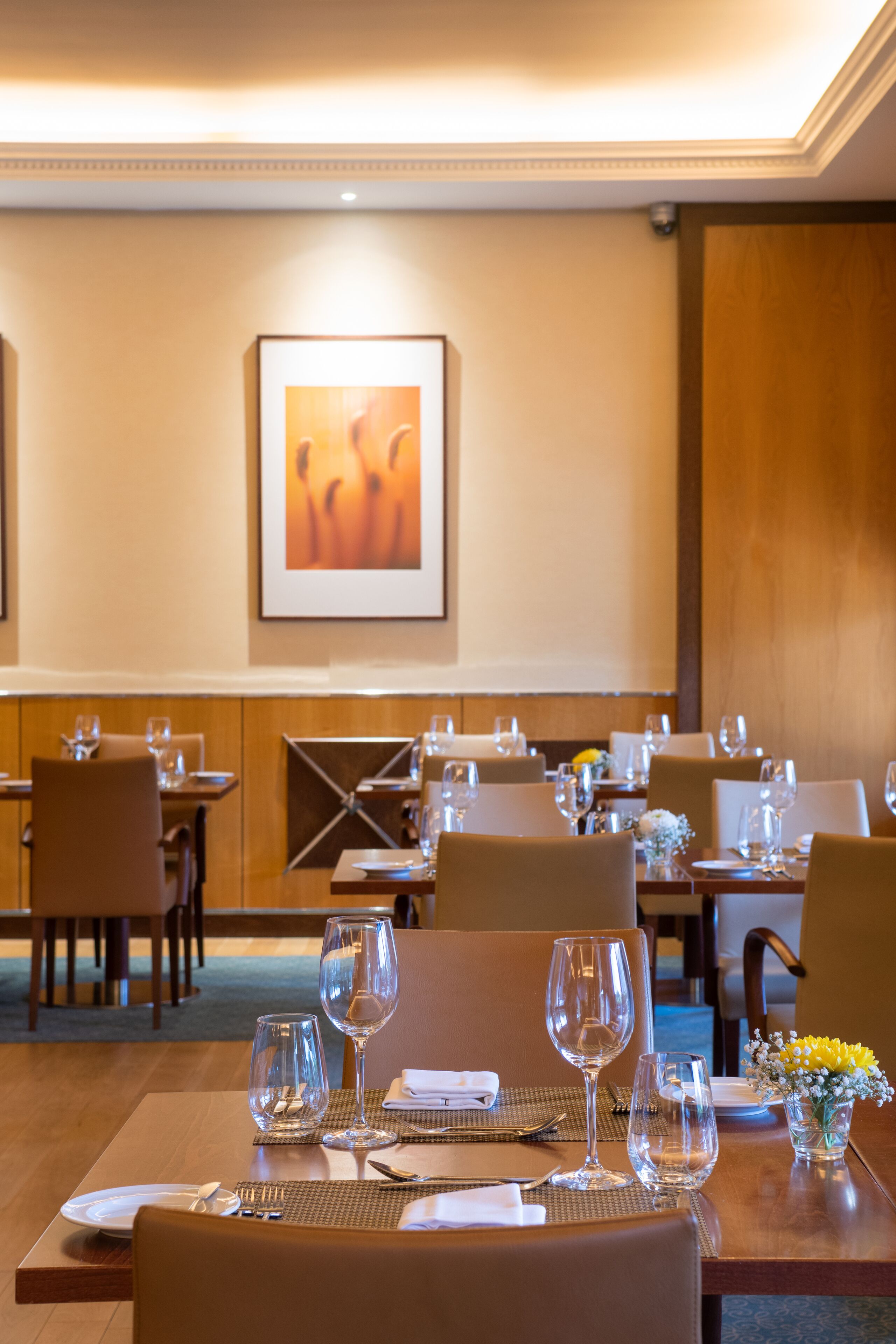 A dining area with tables set for a meal, including wine glasses and cutlery.