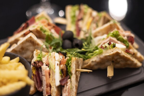 A plate of sandwiches with various fillings and a side of fries.