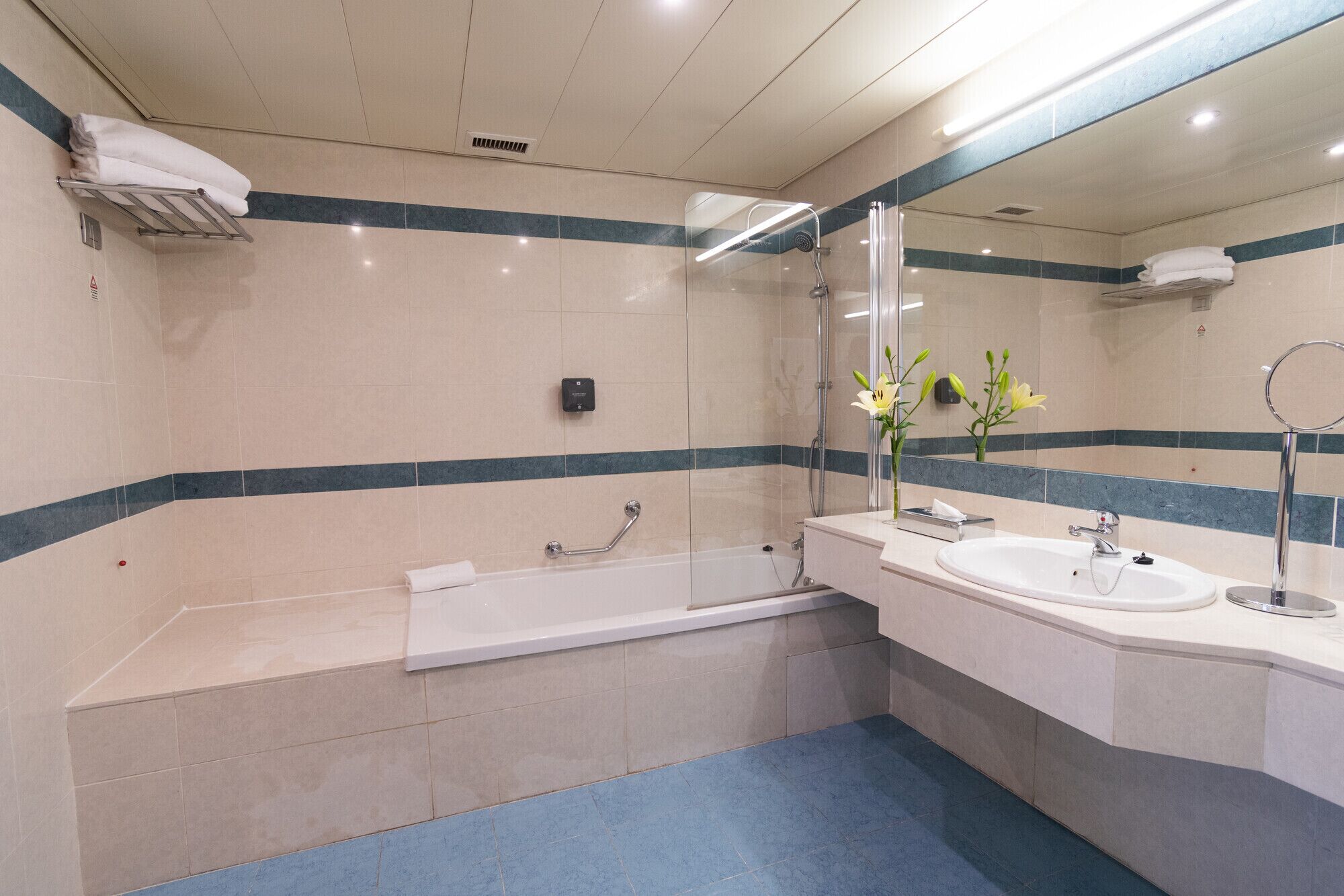 Une salle de bain moderne avec une baignoire, deux lavabos, un miroir et une douche.