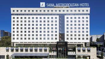 A large, modern hotel building with multiple floors and a prominent sign reading "SANA METROPOLITAN HOTEL".