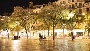 A historic building with a clock tower, surrounded by trees and illuminated by street lamps. - Hotel Metropole (Lisbon)