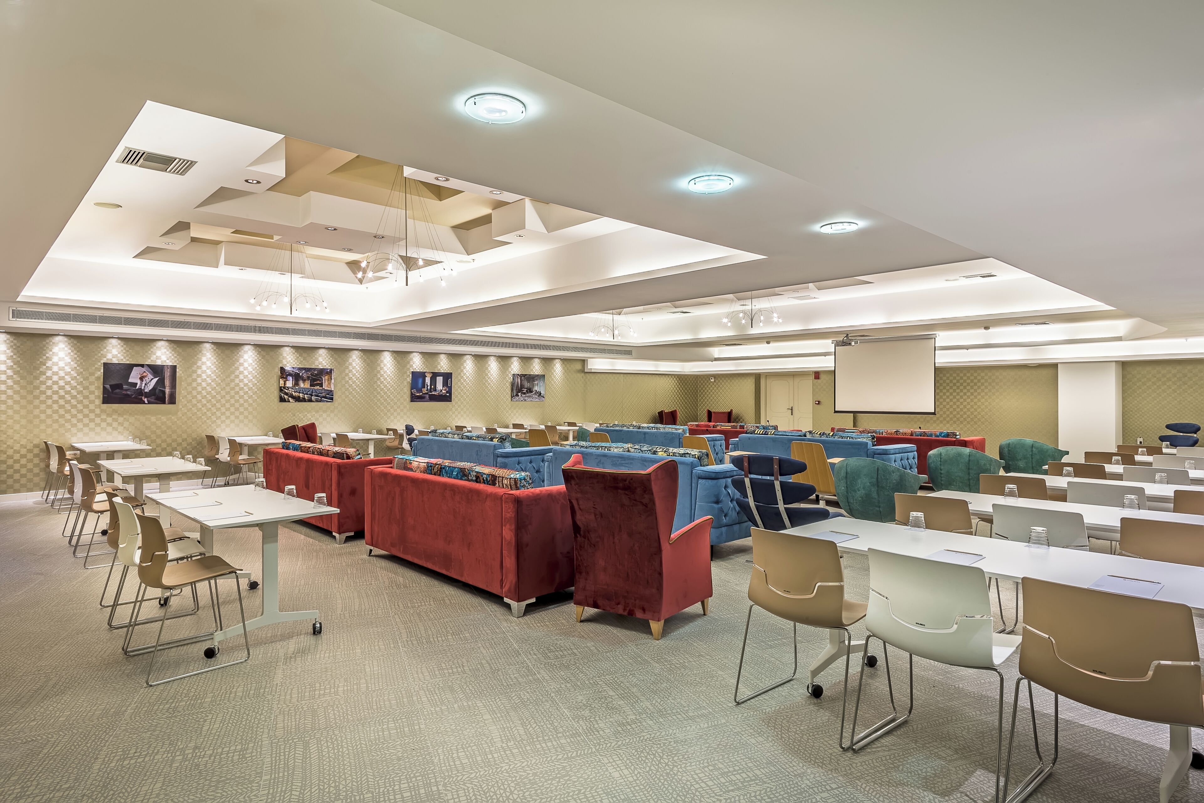 A conference room with tables, chairs, and sofas arranged for meetings.