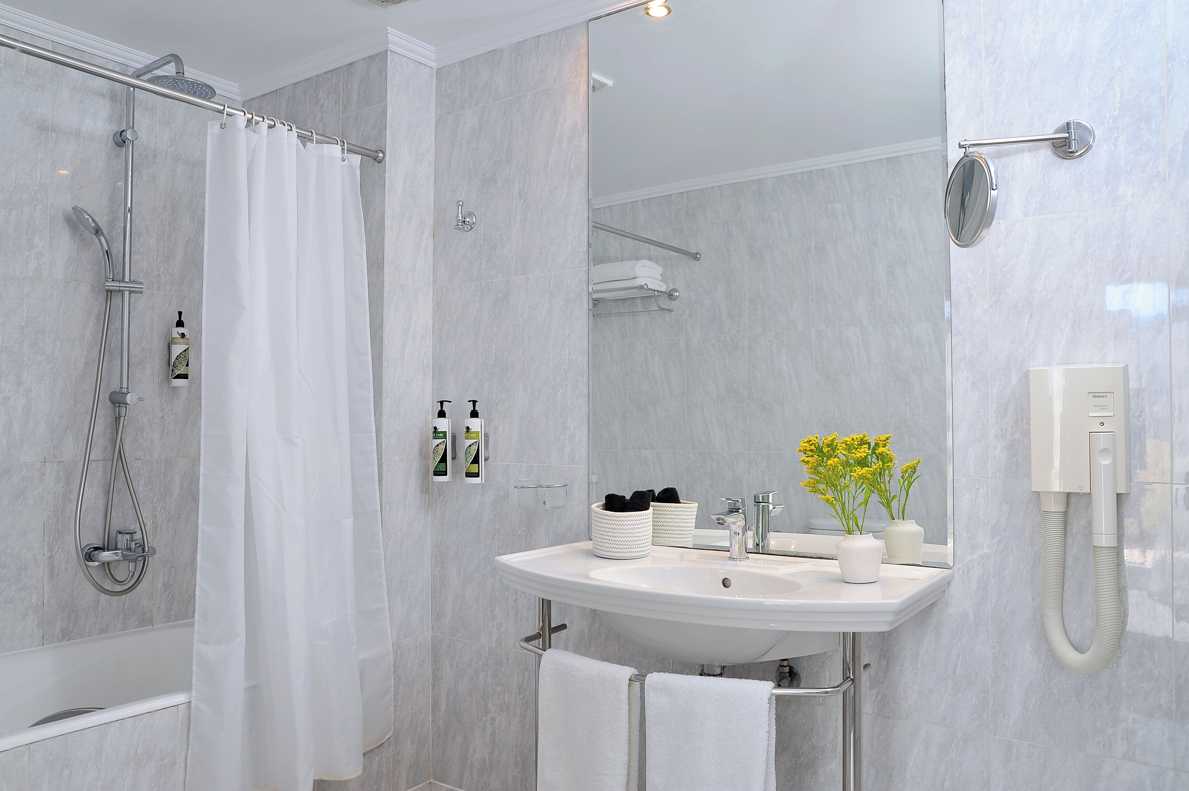Un baño moderno con ducha, lavabo y espejo.