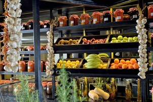 A display of various food items including fruits, vegetables, and preserved goods.