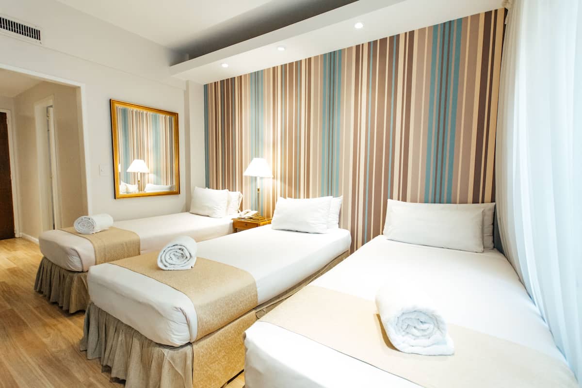 Standard Quadruple Room | Peralatan tempat tidur premium, bar mini, peti besi dalam bilik