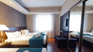 A hotel room with two beds, a TV, a mirror, and a window with curtains. - Dorá Hotel Buenos Aires (Buenos Aires)
