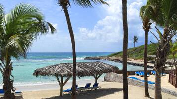 En la playa, playa de arena blanca, camastros y bar en la playa