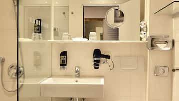 Ein modernes Badezimmer mit Duschkabine aus Glas, einem weißen Waschbecken und einer Toilette.