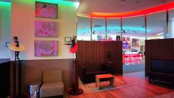 Un interior moderno con una zona de estar, un bar y obras de arte en las paredes.