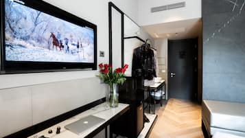 Habitación triple | Edredón, minibar, caja de seguridad en la habitación y escritorio