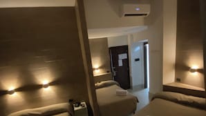 A hotel room with two beds, a small table, and a bedside table with a lamp. - Grand Hotel Olympic (Rome)
