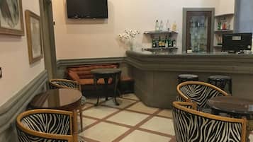 A bar area with a sofa, zebra-patterned chairs, a television, and a display of liquor bottles.