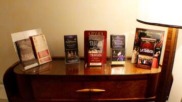 A wooden desk with several books and brochures, including titles like 'The Tenors' and 'Traviata'.