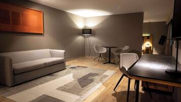 Suite, 1 cama King size | Área de sala de estar | Televisión LCD de 42 pulgadas con canales vía satélite y televisión