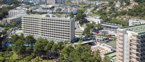 Ein großes Hotel mit mehreren Etagen, einem Schwimmbad und einem Parkplatz.