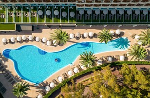 Una piscina al aire libre, sombrillas, tumbonas