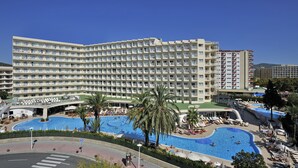 A large hotel with multiple floors, a central swimming pool, and surrounding lounge areas. - Sol Guadalupe (Calvia)