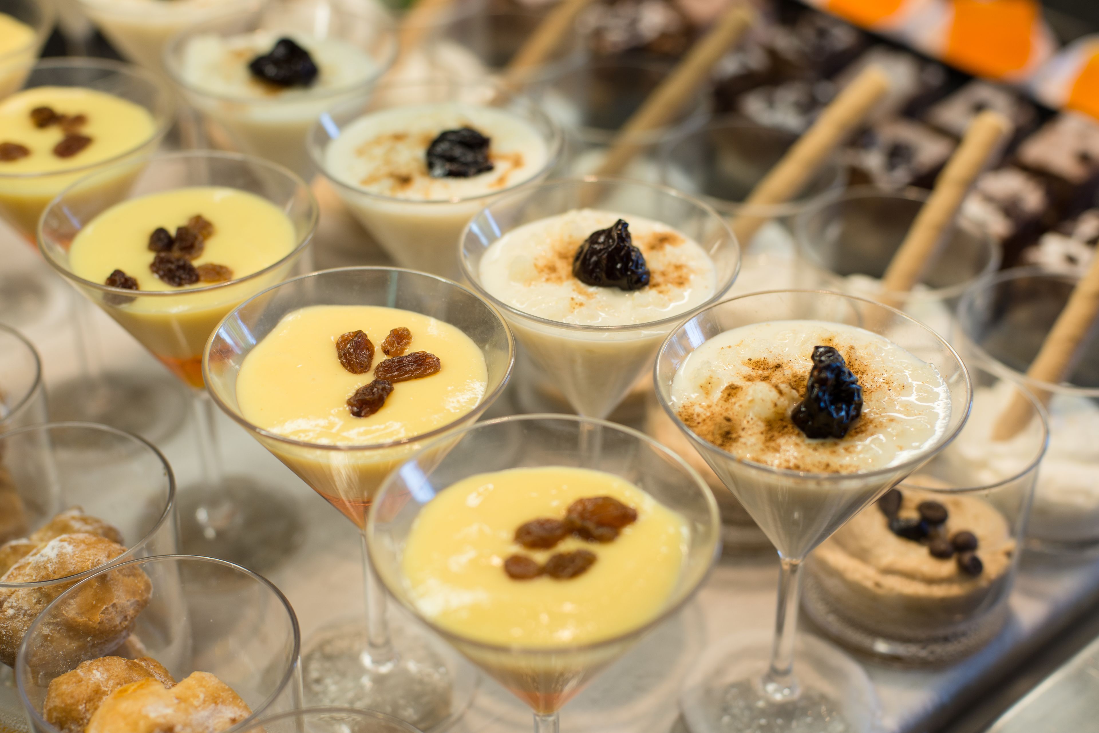 Diversos postres en copas transparentes, incluyendo un pastel de chocolate y un pastel de queso con frutos rojos.